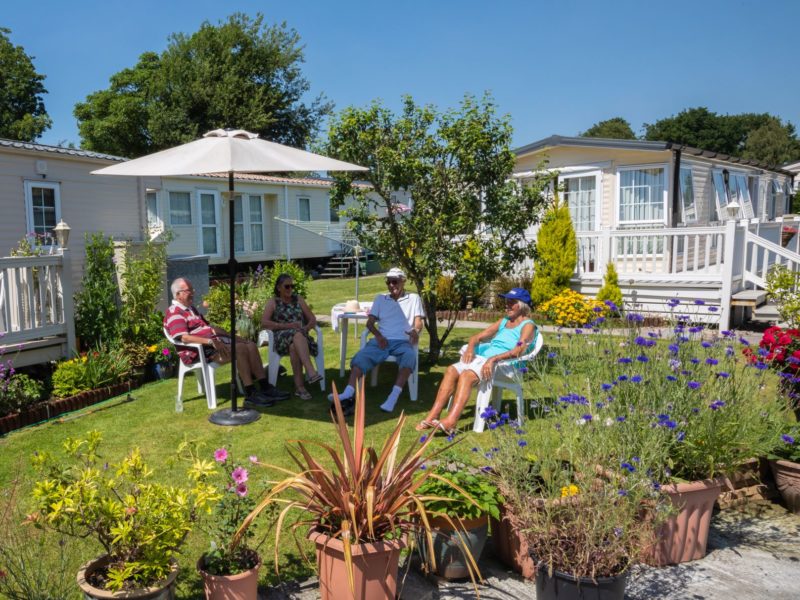 Caravan home owners sitting outside in garden